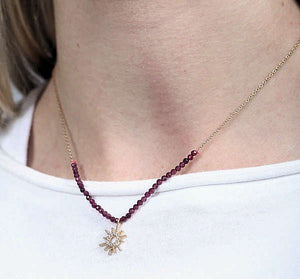 Starburst pendant on necklace with garnets